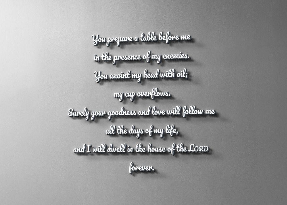 White cursive Psalm 23 wall text with shadows reading You prepare a table about oil, goodness and dwelling forever.