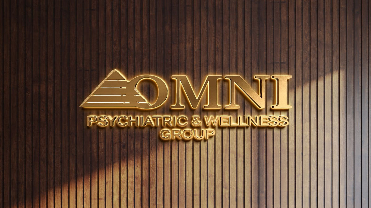Gold illuminated OMNI logo and pyramid icon reading 'PSYCHIATRIC & WELLNESS GROUP' on dark vertical wood paneling.
