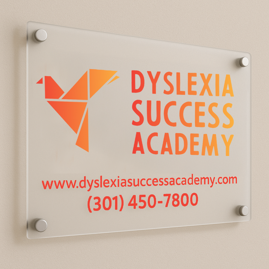 A frosted glass wall sign shows an orange geometric bird logo and the words Dyslexia Success Academy.
