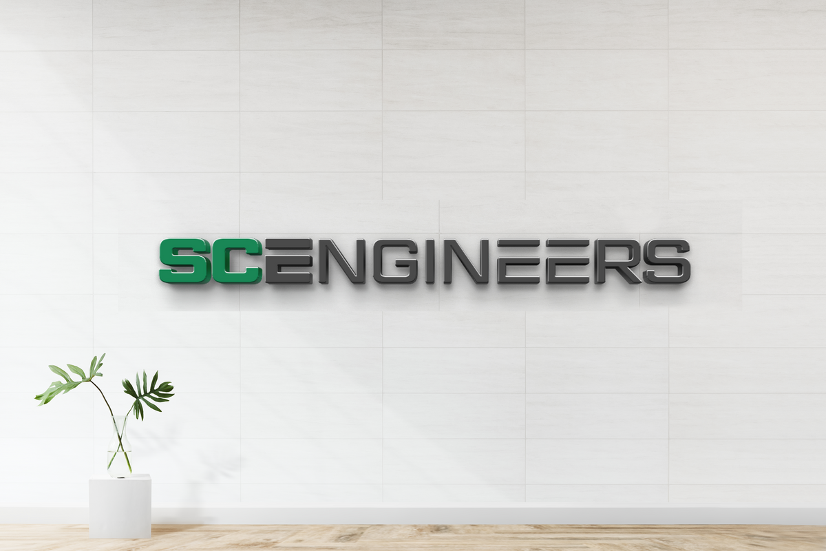 3D logo signage SC ENGINEERS with green SC and dark gray letters on white tiled wall above glass vase with leaves.