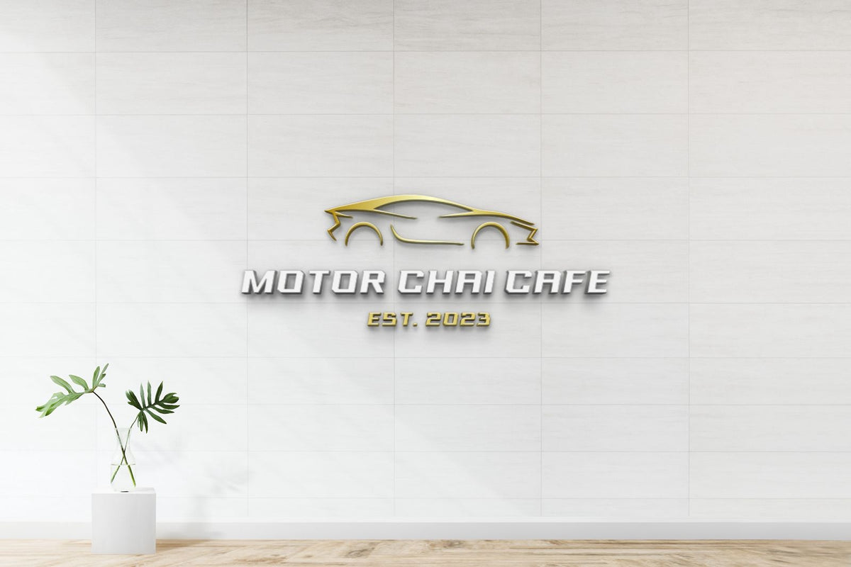 Gold car outline logo and silver 'MOTOR CHAI CAFE' with gold 'EST. 2023' on white tiled wall, small potted plant.