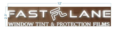 Illuminated FAST LANE sign with stylized F and WINDOW TINT & PROTECTION FILMS text on brown wood, marked 12'×2.3'.