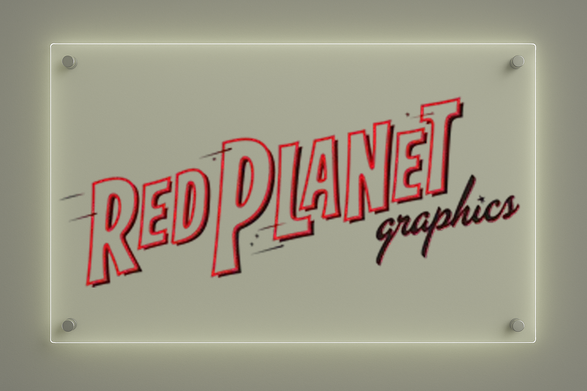 A backlit acrylic wall sign with red outlined 'RED PLANET' lettering and black cursive 'graphics' mounted on gray wall.