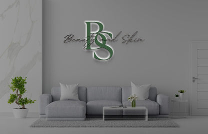Gray modern lounge with light-gray sofa, coffee table, potted bonsai, plants, and green 'BS' Beauty and Skin logo.