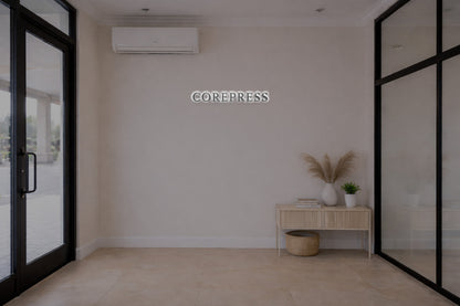 Beige entry wall with 'COREPRESS' sign and white AC, black glass doors, wood console, vase, pampas and basket