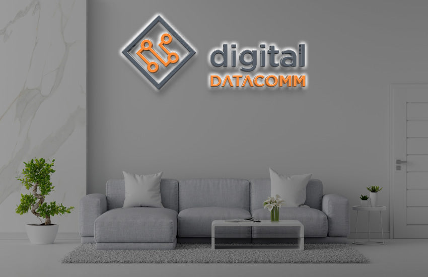 Digital Datacomm 3D halo backlit logo sign with orange circuit board diamond icon and gray wordmark on office lounge wall mockup.