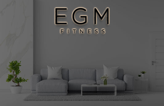 Backlit 3D EGM Fitness custom wall sign mockup above gray sofa with modern home interior by Volt Signs