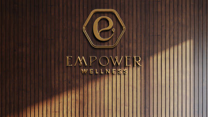 Gold hexagon emblem with stylized 'e' and metallic EMPOWER WELLNESS lettering mounted on vertical dark wood slat wall.
