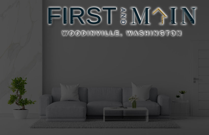 Custom First and Main Woodinville Washington 3D halo backlit dimensional letter sign by Volt Signs, navy with gold house roof accent for community brand.
