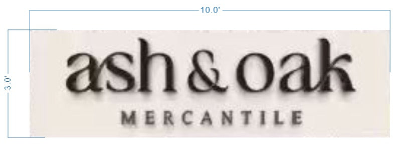 Beige sign with black serif 'ash & oak' above small uppercase 'MERCANTILE', blue dimension lines reading 10.0'×3.0'.