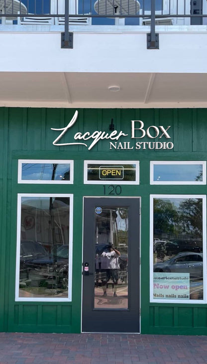 Lacquer Box Nail Studio green storefront with white script sign, black glass door, neon OPEN and address 120.