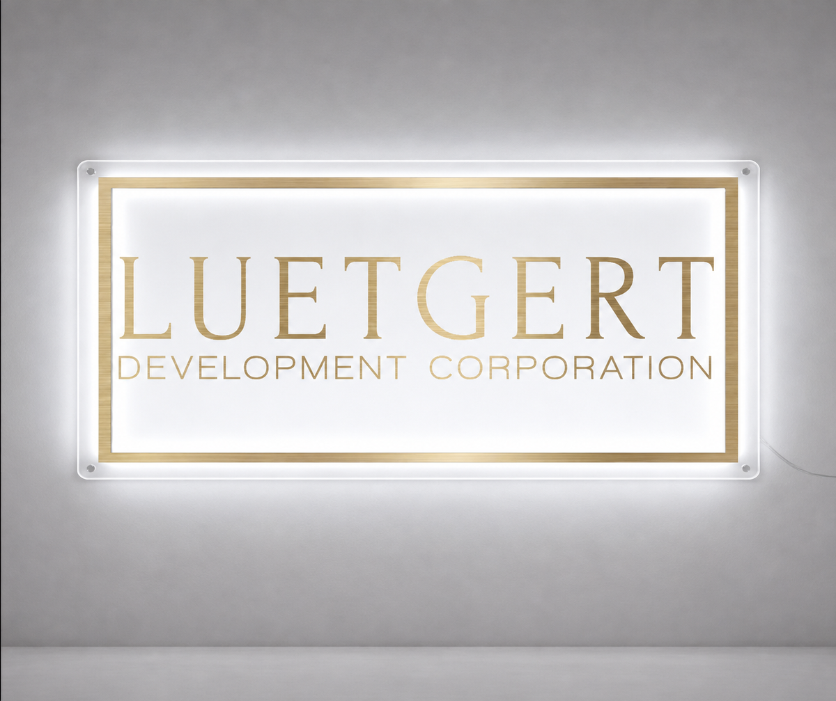 Backlit acrylic custom sign mockup with gold lettering and border for Luetgert Development Corporation by Volt Signs