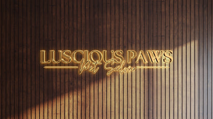 Gold neon sign reading 'LUSCIOUS PAWS Pet Salon' mounted on vertical dark walnut wood slat wall with warm glow.