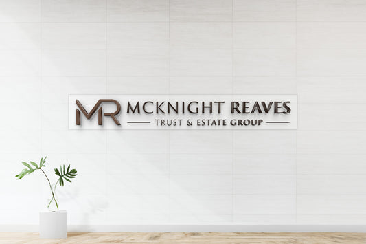 McKnight Reaves Trust & Estate Group 3D bronze letter sign on clear acrylic backplate, nonlit office wall mockup with standoff mounting.