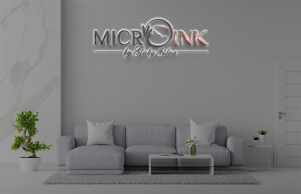 Microink by Gaby Silva 3D halo backlit logo sign with silver and rose gold lettering and feather emblem on lounge wall mockup, microblading studio.