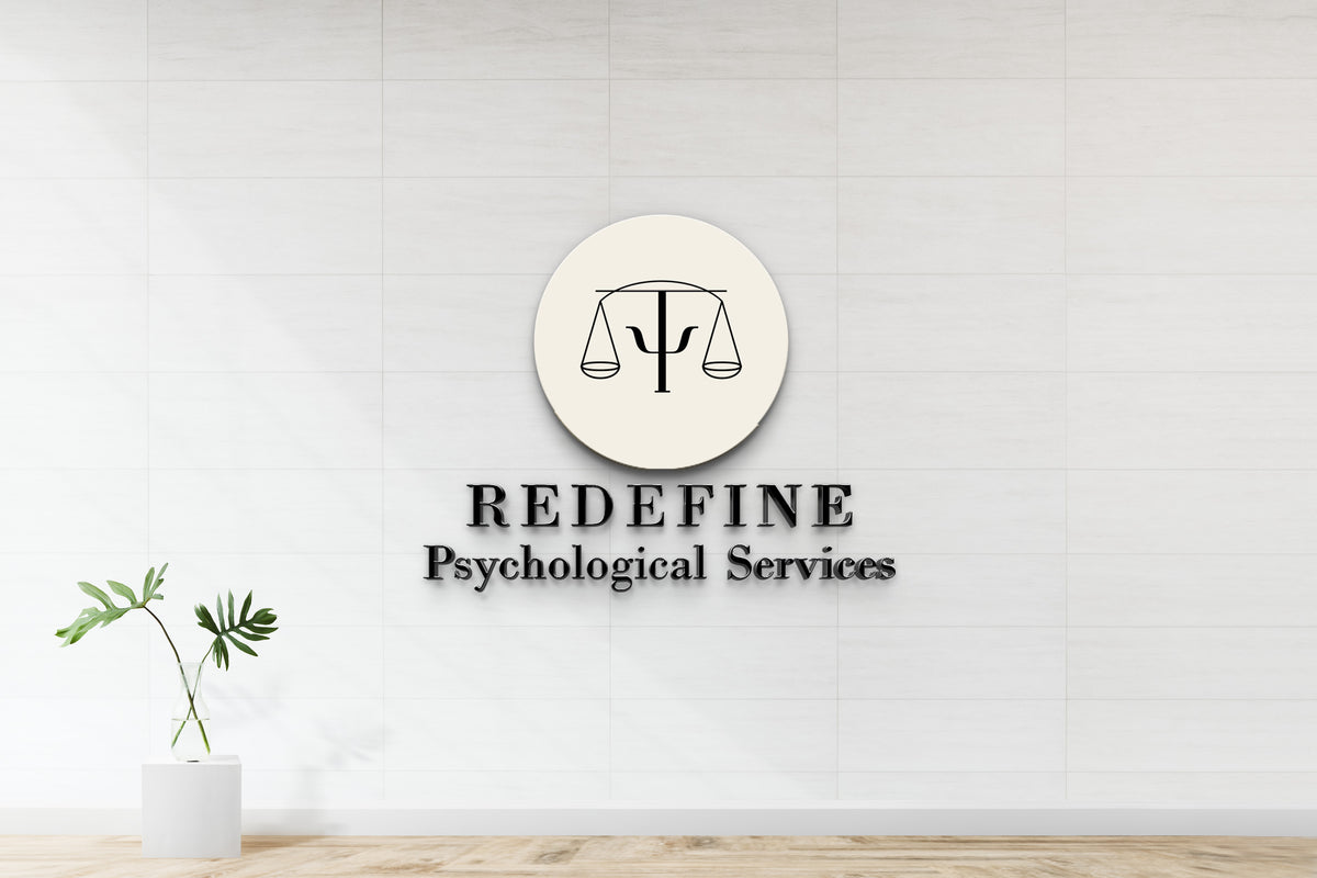 Beige circular logo with scales and psi on white tiled wall, 'REDEFINE Psychological Services' text, green vase plant.