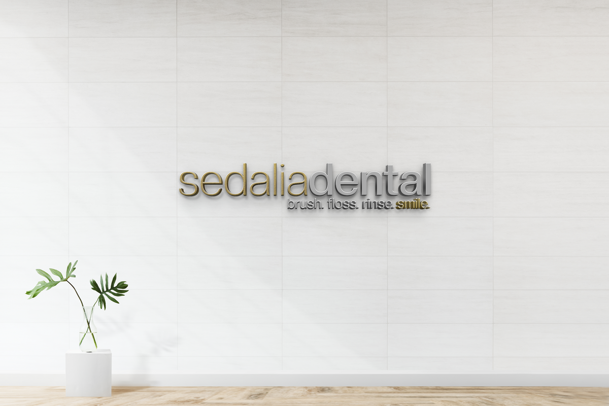 Modern custom wall sign for Sedalia Dental with gold and silver 3D lettering on white tile wall by Volt Signs.