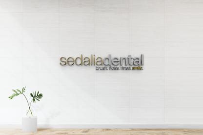 Modern custom wall sign for Sedalia Dental with gold and silver 3D lettering on white tile wall by Volt Signs.