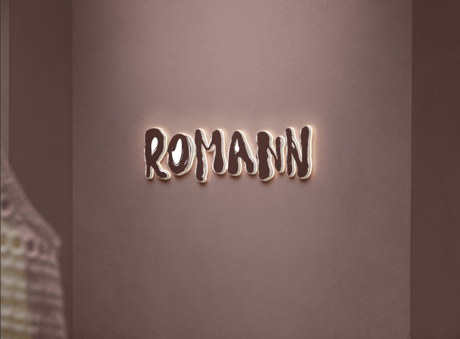 Glowing brown neon sign reading 'ROMANN' mounted on a mauve-pink wall with soft halo light and blurred garment edge.