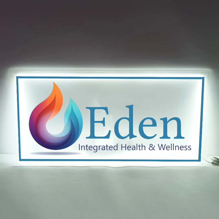 Illuminated white sign with multicolored flame-drop logo, blue Eden text and Integrated Health & Wellness tagline.