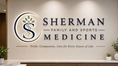 Illuminated custom wall sign mockup for Sherman Family and Sports Medicine with blue letters and medical logo