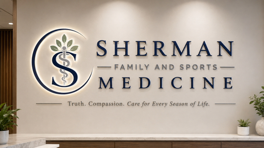 Illuminated custom wall sign mockup for Sherman Family and Sports Medicine with blue letters and medical logo