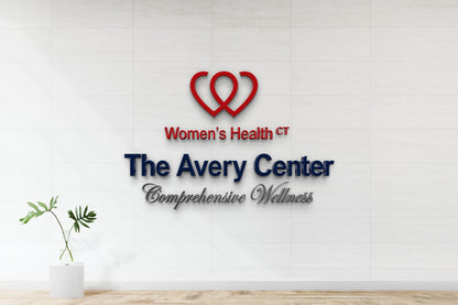 The Avery Center 3D dimensional logo with red heart icon, navy wordmark and chrome script tagline, nonlit medical office mockup.
