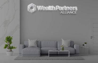 Modern gray living room with gray sofa, glass coffee table, potted plants and illuminated 'Wealth Partners ALLIANCE' ...