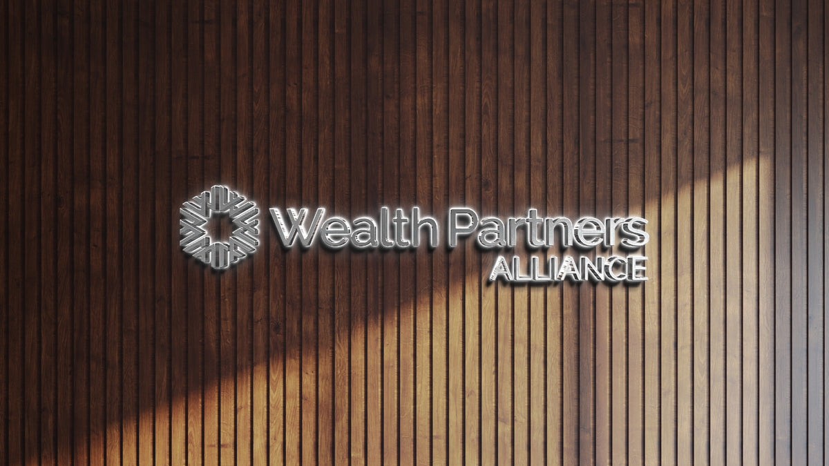 Illuminated metallic 'Wealth Partners ALLIANCE' logo and emblem on dark vertical wooden slat wall with sunlight