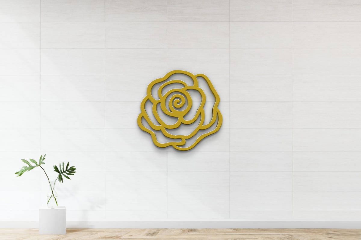 Golden yellow rose outline sculpture centered on white tiled wall above wood floor, glass vase with green leaves left.