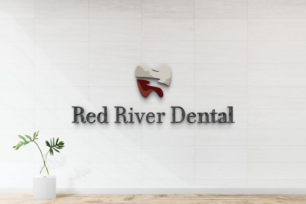 Modern Red River Dental wall sign: metallic serif letters under tooth logo with red river on white tiled reception wall.