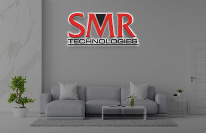 SMR TECHNOLOGIES red and black logo on gray wall above light-gray sofa with white pillows, glass table, potted plants.