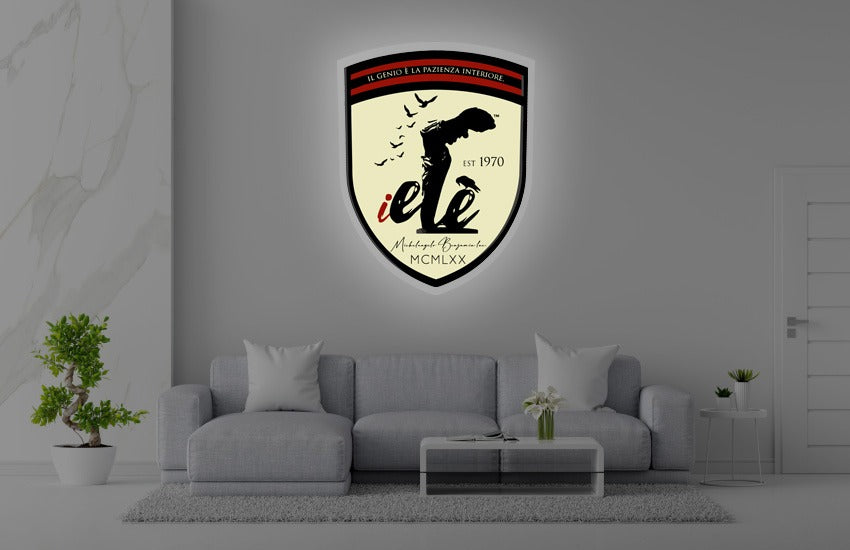 Grey living room with shield-shaped illuminated wall plaque showing black figure silhouette, red stripe, EST 1970.