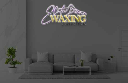 Illuminated custom wall sign for Elite Waxing & Skin Studio by Volt Signs above gray couch in purple and gold.