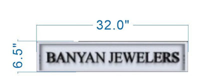 White rectangular sign 'BANYAN JEWELERS' in black text with blue measurement lines labeled 32.0" by 6.5".