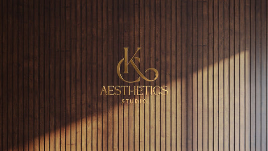 Elegant gold metal custom wall sign for JK Aesthetics Studio mounted on vertical dark wood paneling by Volt Signs