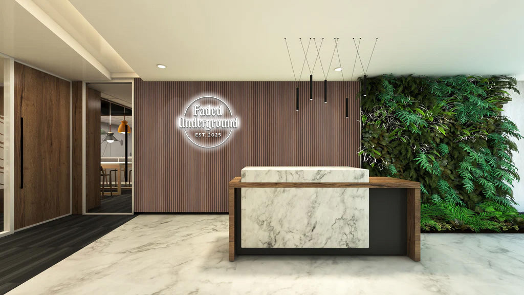 Marble reception desk with wood trim, vertical slat wall with illuminated Faded Underground Est 2025 sign and plant.