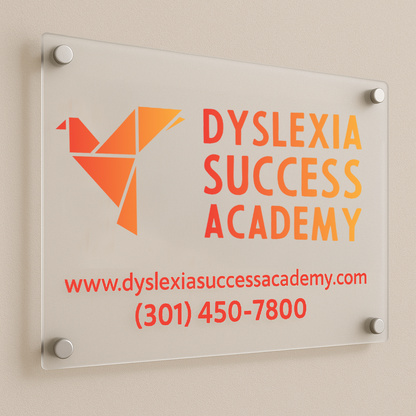 A frosted glass wall sign shows an orange geometric bird logo and the words Dyslexia Success Academy.
