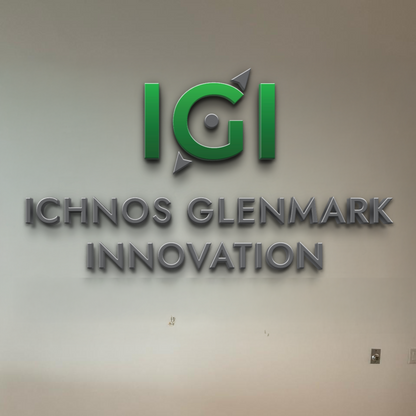 Volt Signs custom sign with a green circular logo and arrows above raised metallic ICHNOS GLENMARK INNOVATION signage
