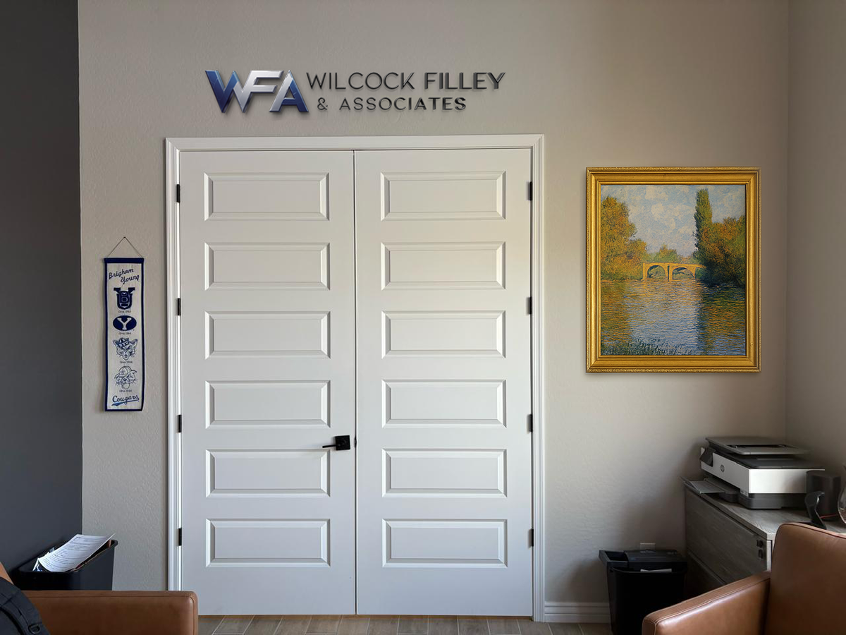 Office interior with WFA Wilcock Filley & Associates logo above white double doors, framed river painting and printer.