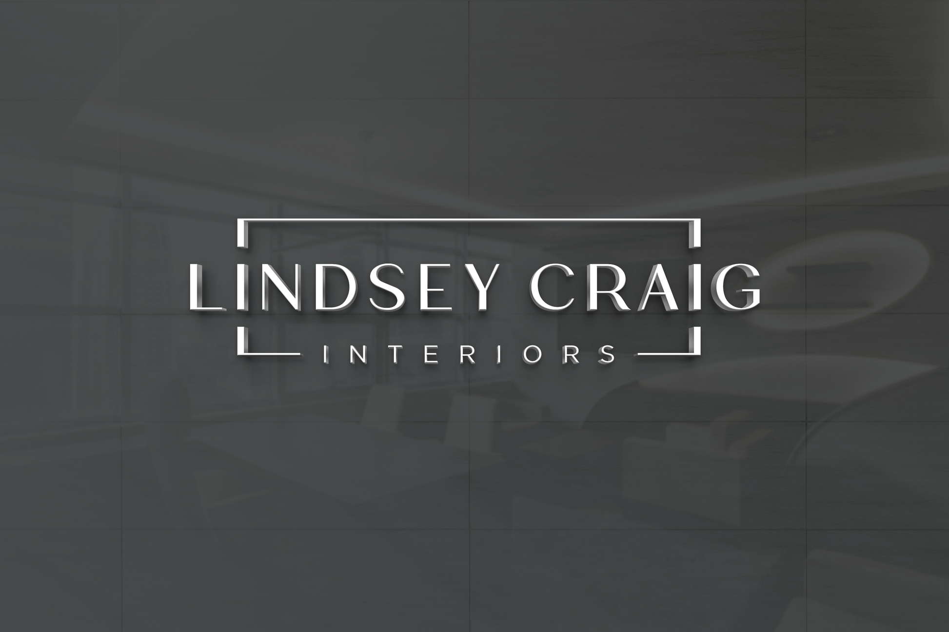 White 3D lettering 'LINDSEY CRAIG' framed by white corner brackets with 'INTERIORS' below on dark gray reflective wall.