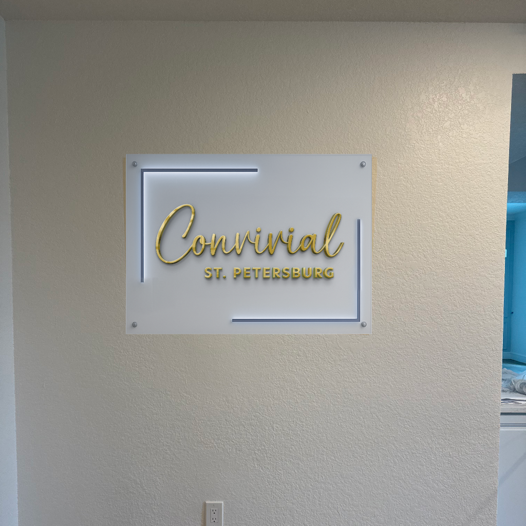 A Volt Signs illuminated custom sign reading Convivial St. Petersburg showcases modern signage on a textured beige wall