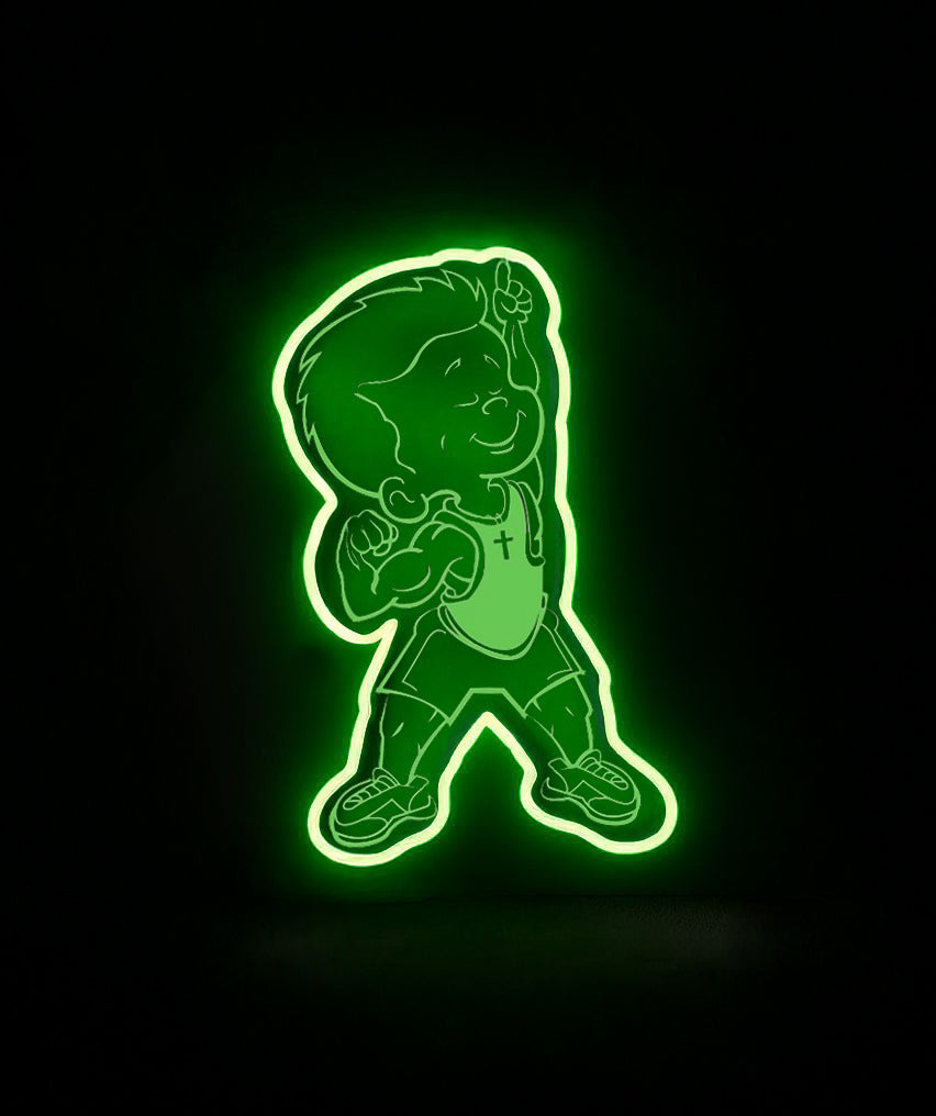 Neon green LED sign of a smiling cartoon boy wearing a backpack and cross necklace, pointing upward on black background.