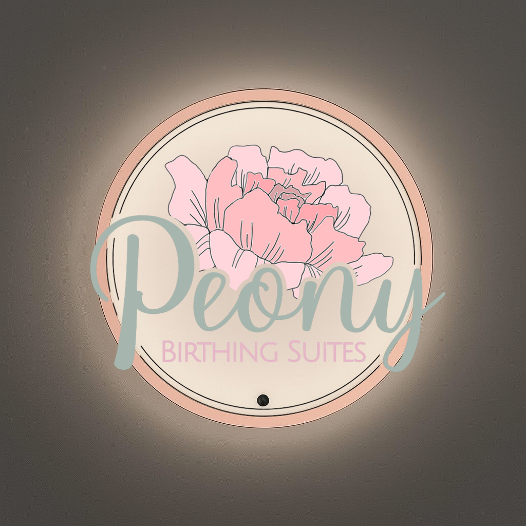 Wall-mounted round illuminated sign with pink peony illustration, teal 'Peony' script and pink BIRTHING SUITES.