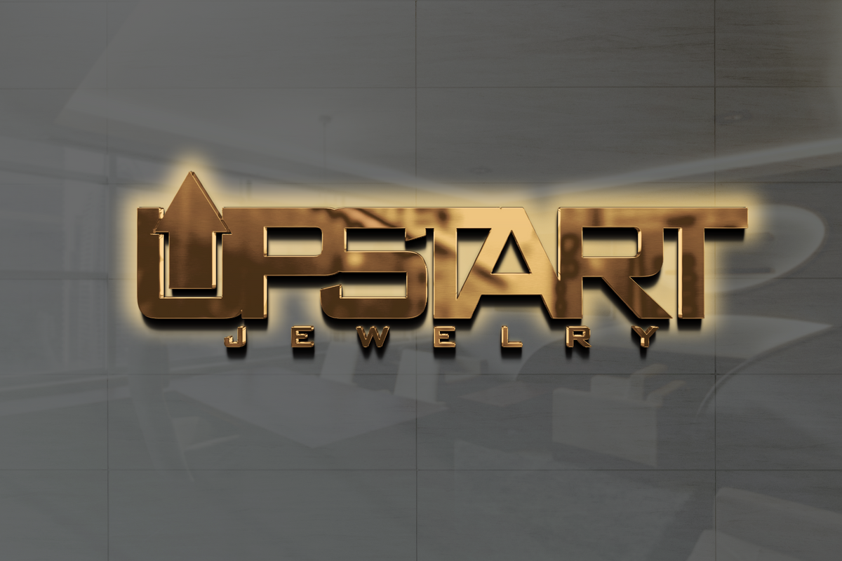 Gold metallic 3D 'UPSTART' jewelry sign with upward arrow integrated in letter U, warm halo backlit on gray tiled wall.